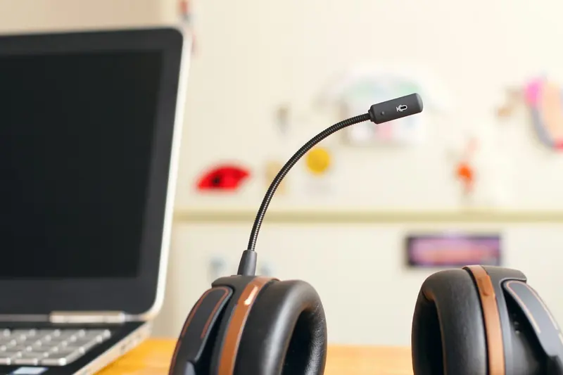 Casque d'écoute posé près d'un ordinateur portable, poste de travail d'une adjointe virtuelle