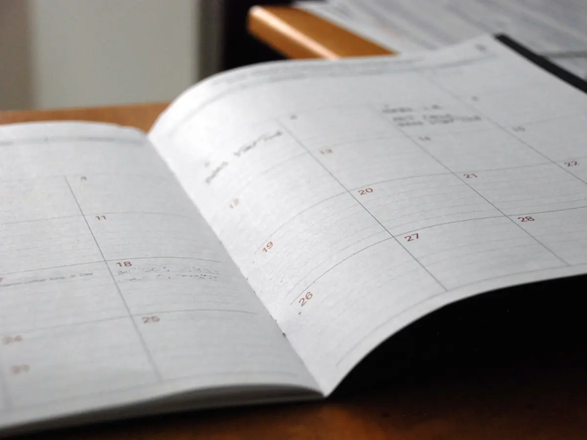 Agenda papier ouvert sur un bureau, avec des rendez-vous notés à la main