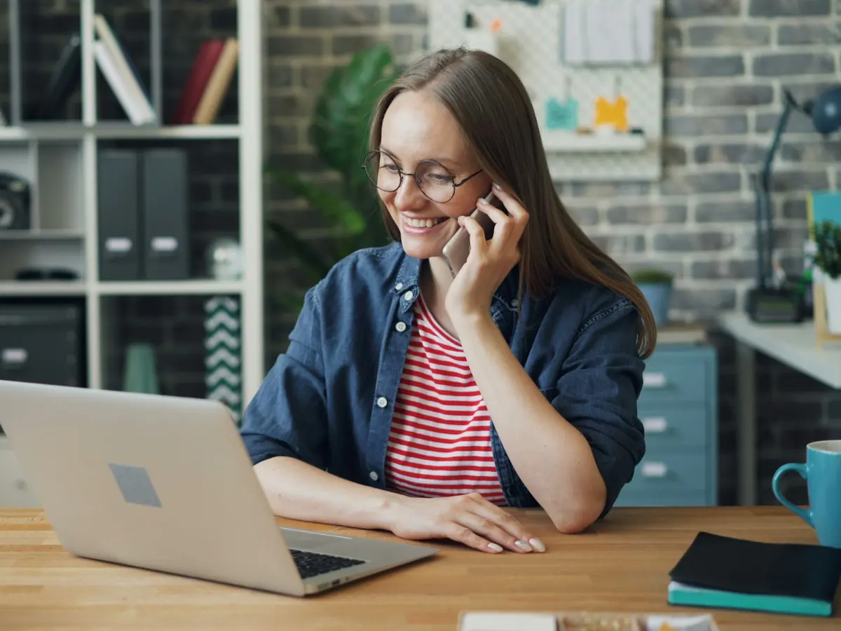 Propriétaire d'entreprise qui prend un appel en consultant son ordinateur portable