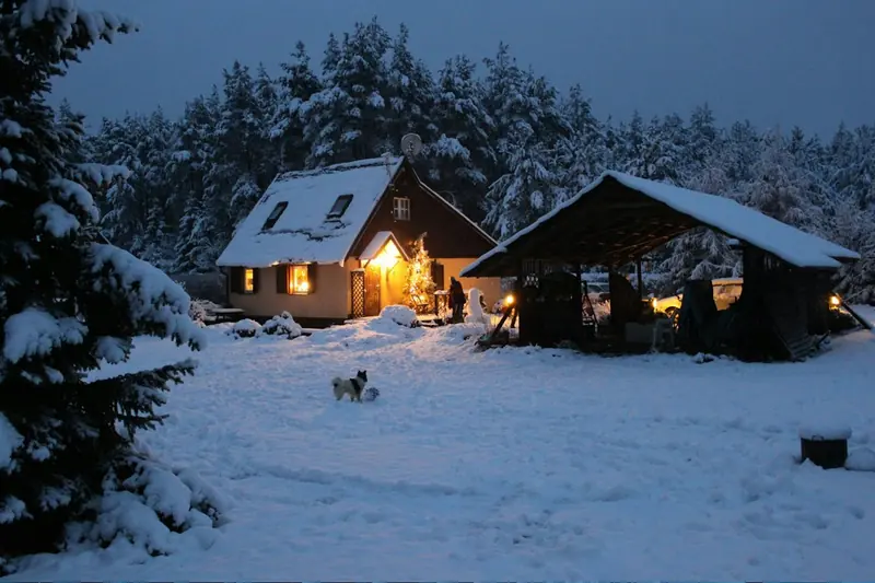 Maison éclairée un soir d'hiver, au moment où les propriétaires appellent