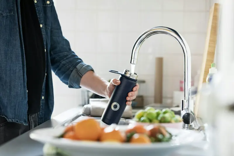 Plombier au travail sur un robinet de cuisine