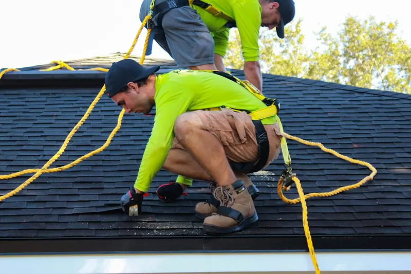 Deux couvreurs au travail sur le toit d'une maison